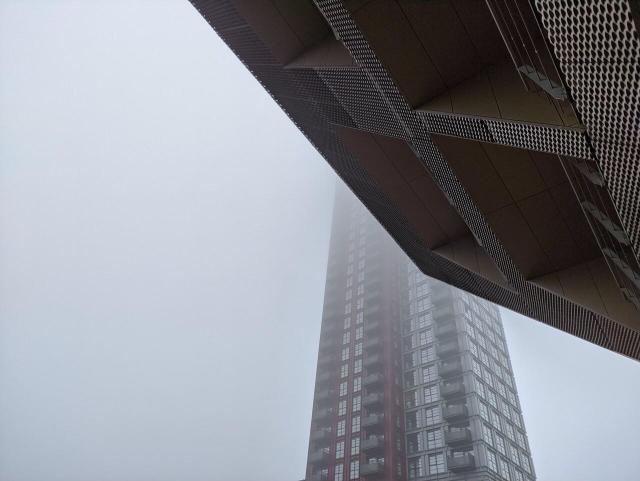 Misty view of new tower in Canada Water, with library in foreground